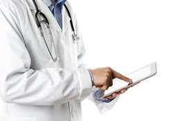 Ein Arzt hält ein Tablet in der Hand