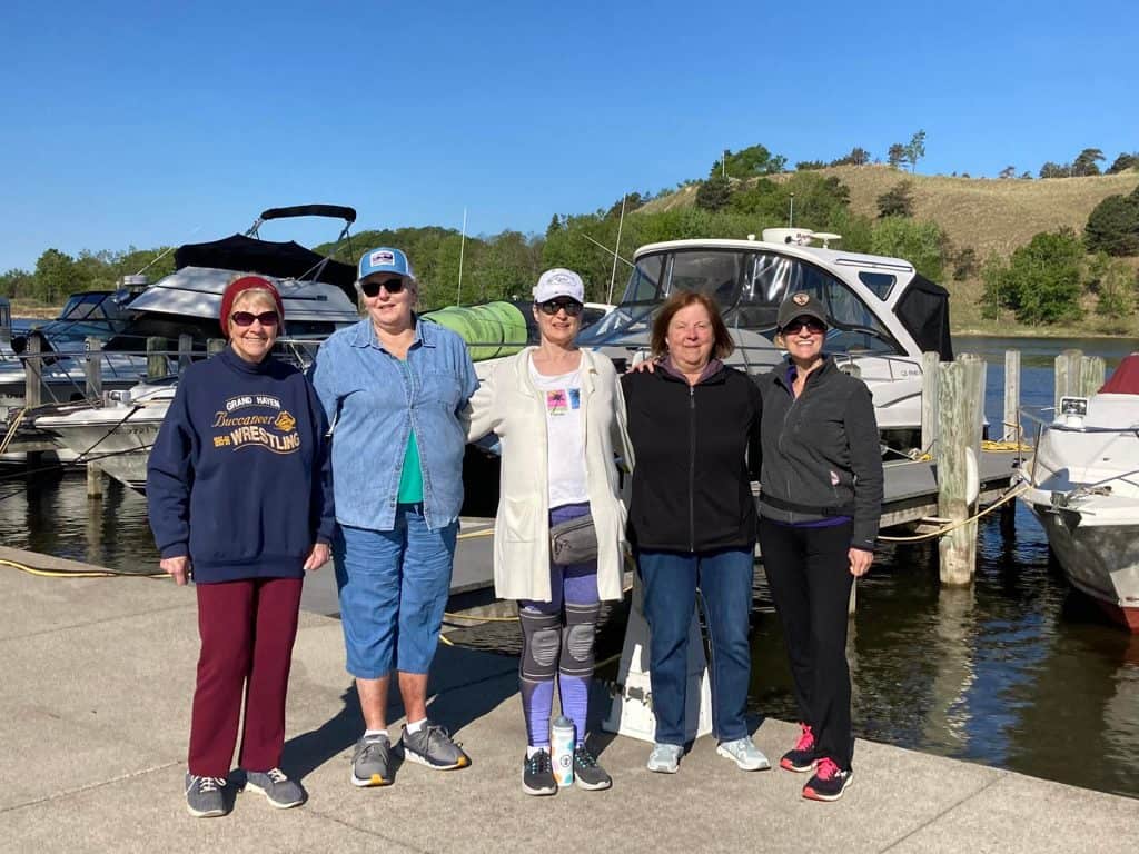 Group of women standing by boats at marina for Four Pointes Aging Center.