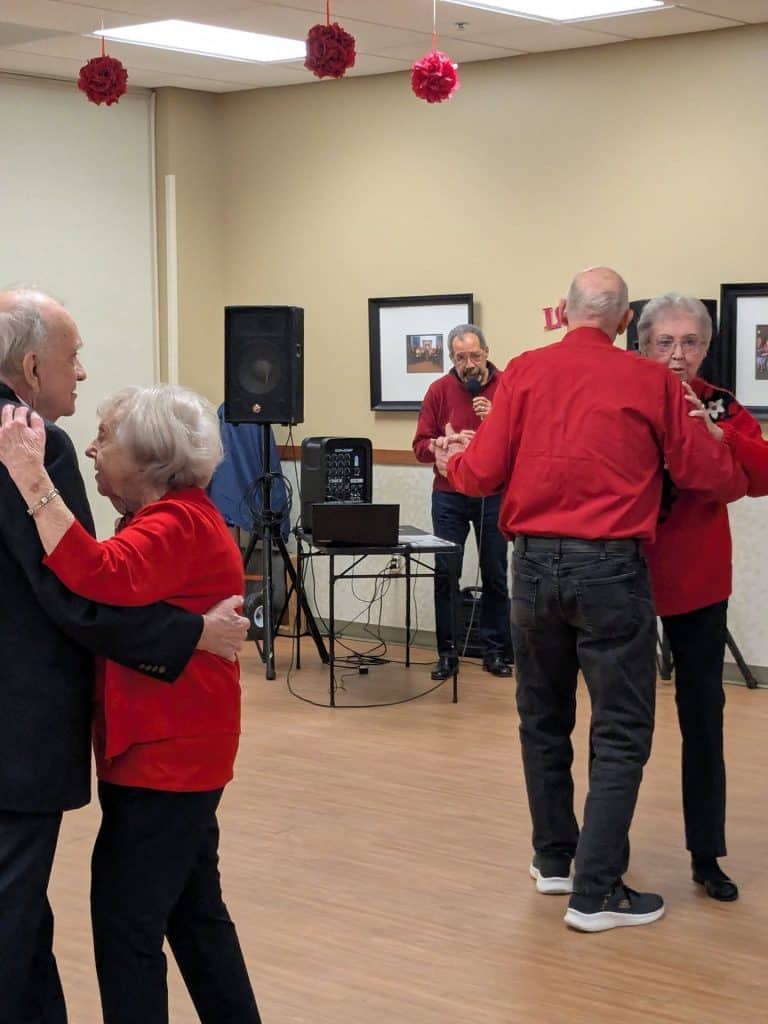 Senior couples dancing at a social event with live music in the background.