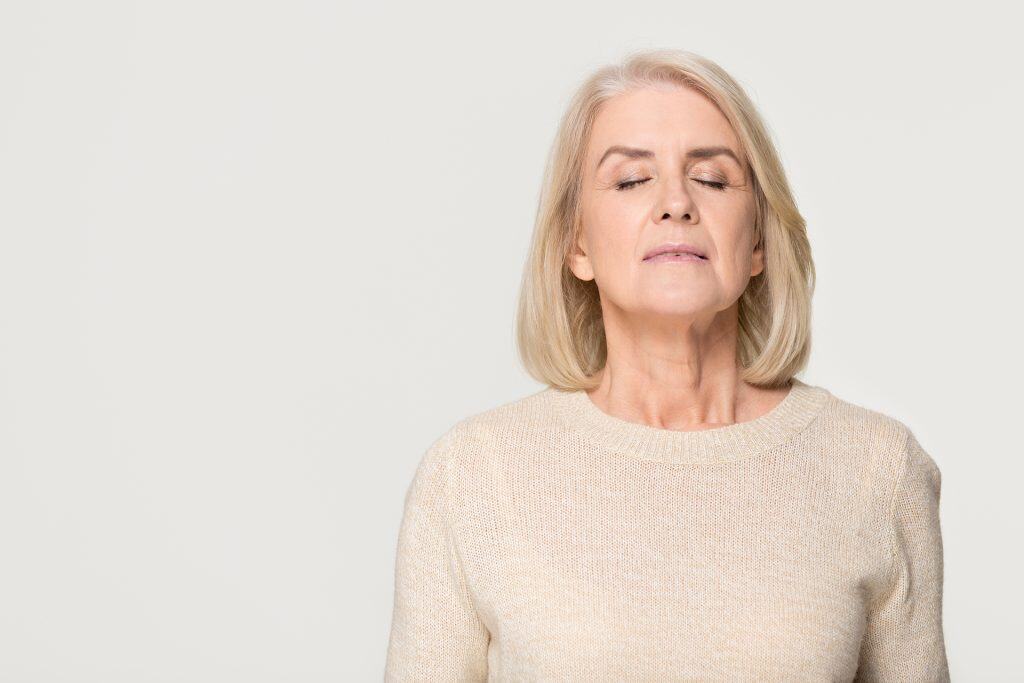 Senior woman with closed eyes practicing mindfulness and relaxation.