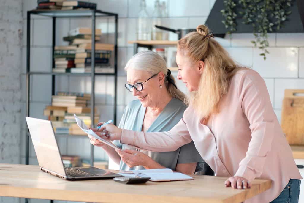 Senior woman and young woman reviewing Medicare documents together.