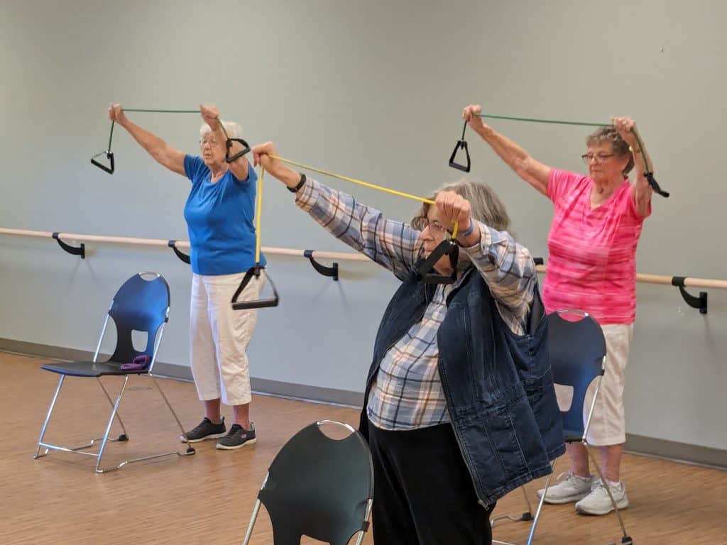 Senior women using resistance bands for exercise in a fitness class.