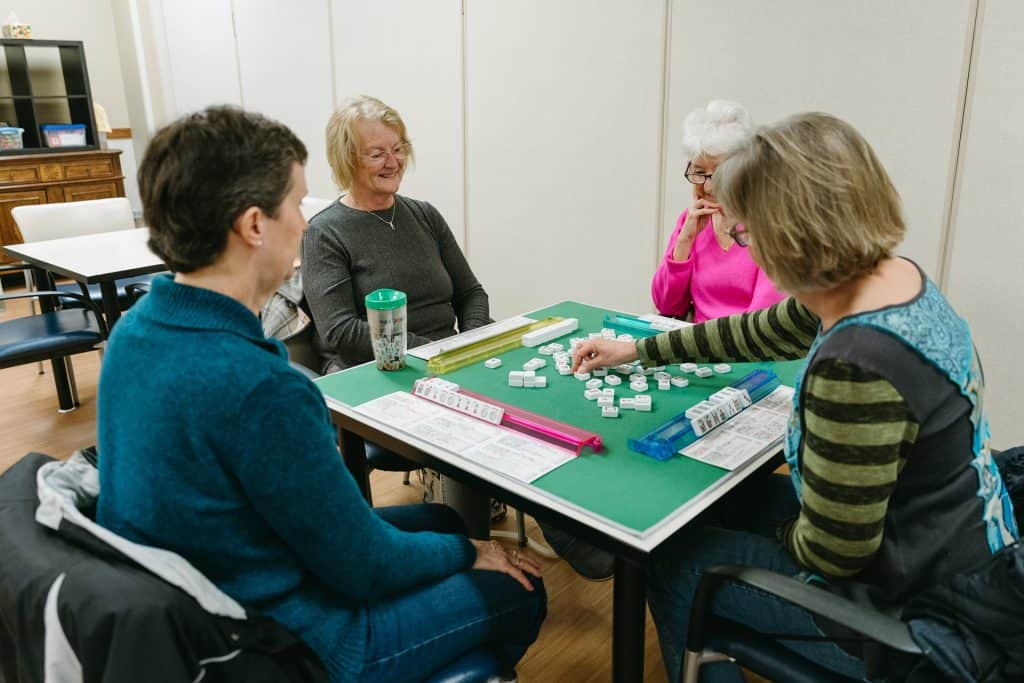 Older adults playing dominoes at Four Pointes Center for Successful Aging.