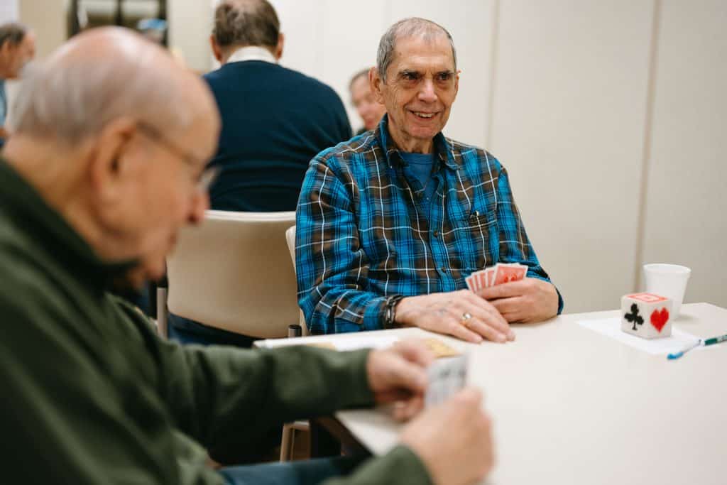 Elderly men enjoying a card game at a social gathering.