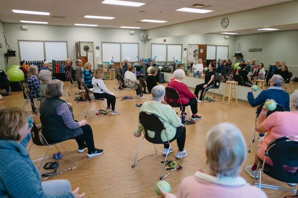 Elderly people participating in a seated exercise class at Four Pointes Center for Successful Aging.
