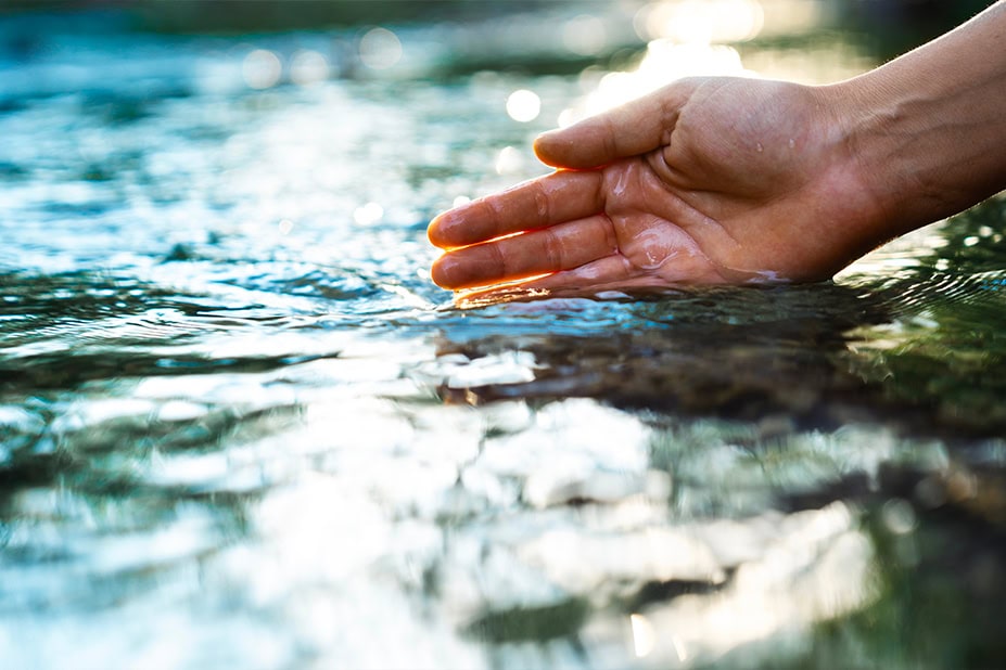Mano che tocca dell'acqua