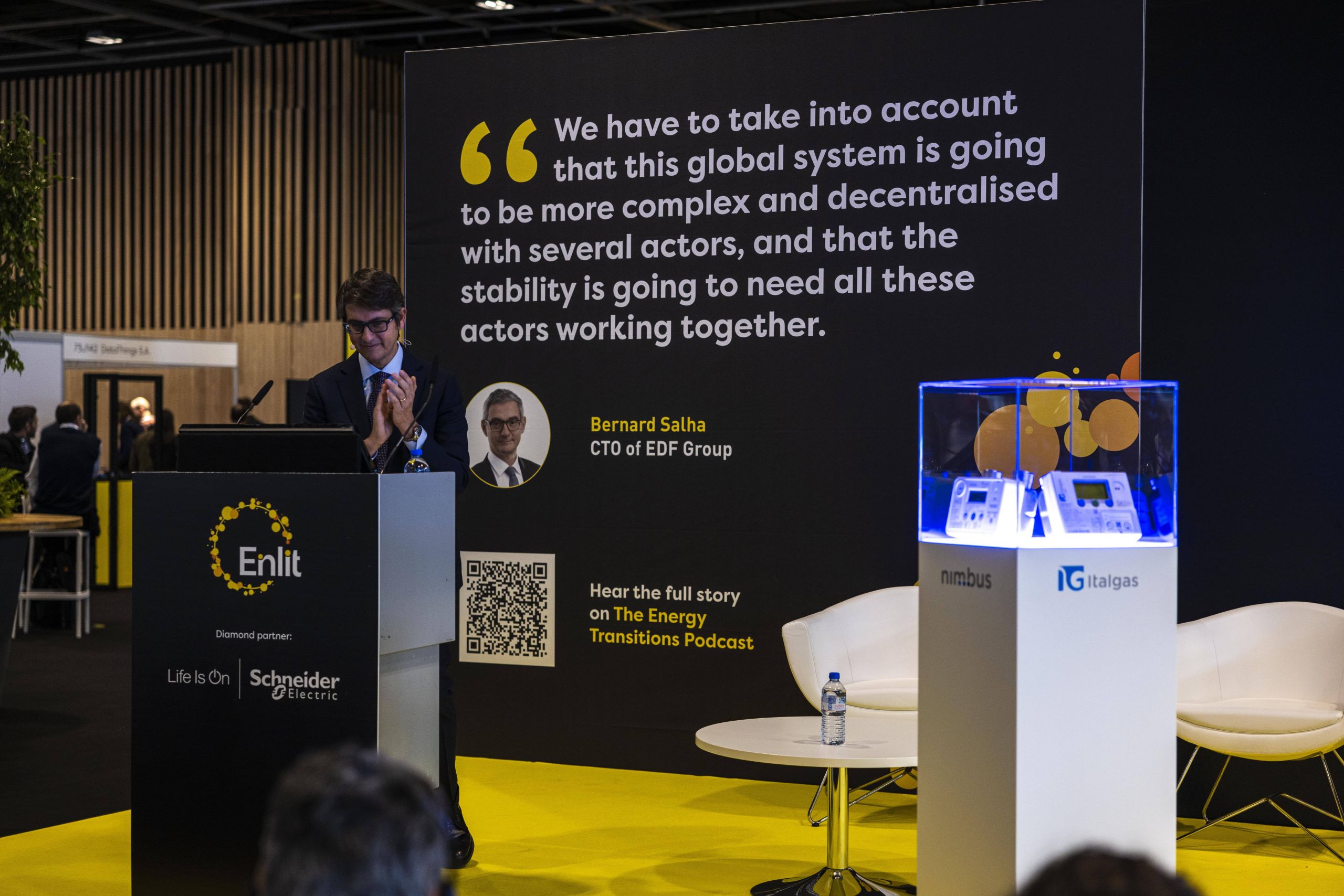 Pier Lorenzo Dell'Orco applauds at a conference with Italgas branding and a quote from Bernard Salha about global system complexity.