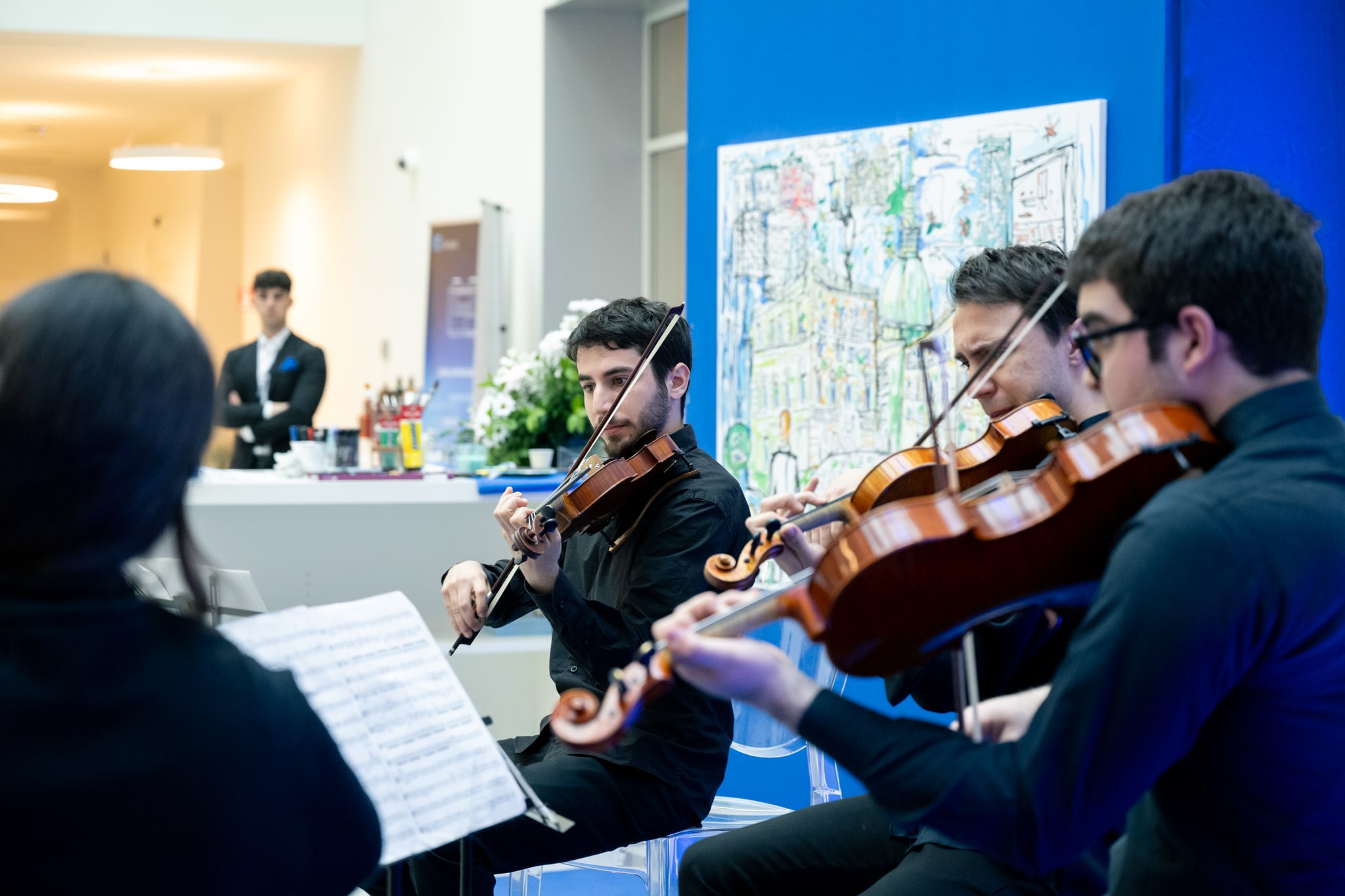 String quartet performing at Planet Week event by Italgas with attendees in the background.