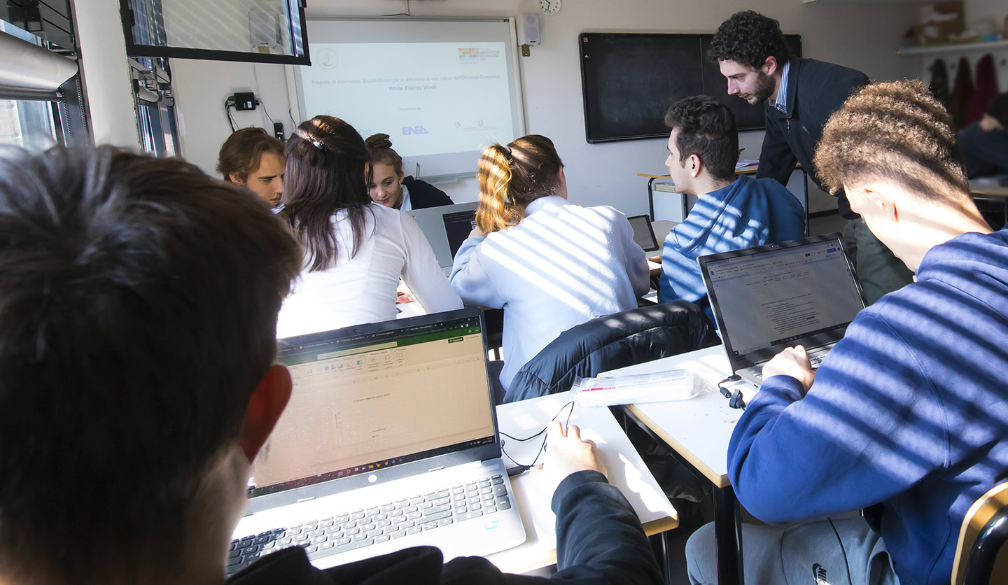 Istruttore Italgas con studenti e laptop durante progetto educativo scolastico.