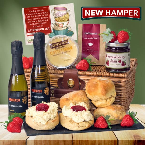 The Prosecco Cream Tea Gift Hamper includes scones with clotted cream and jam, two bottles of Prosecco, a tea packet, fresh strawberries, all in a wicker basket with a sign that reads "NEW HAMPER.