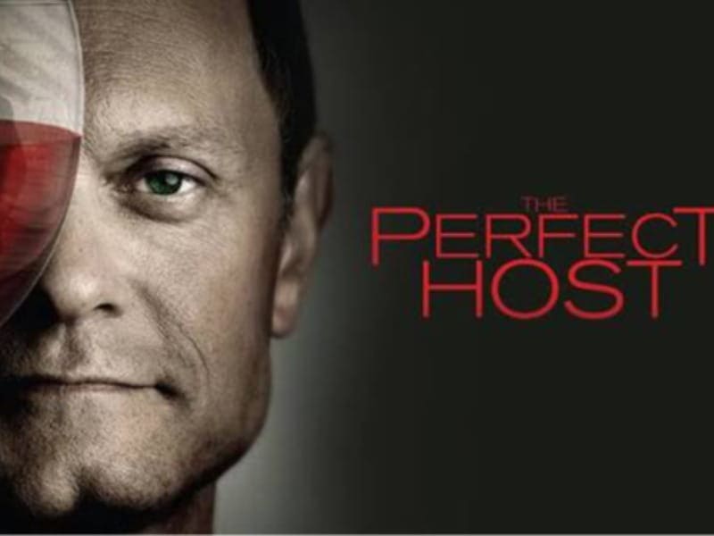 A man’s face is partially obscured by a glass of red wine; “The Perfect Host” appears in red text, evoking the suspense of classic Horror Movies on a black background beside him.