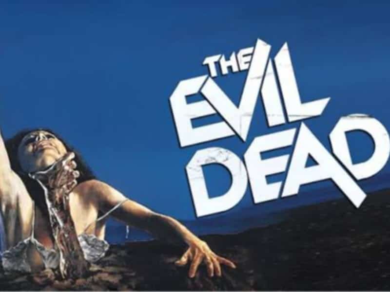 A woman reaches upward from the ground while being grabbed by a hand, with “The Evil Dead” above her—a chilling pick for your 31 Days of Horror Movies.