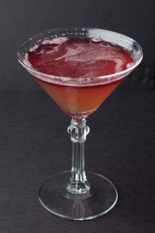 A martini glass with a red liquid in it.