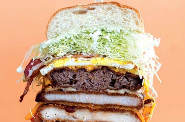 A burger with meat, cheese, lettuce, and other toppings.