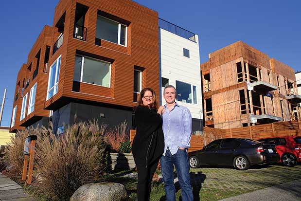 A man and woman standing in front of a new apartment building.