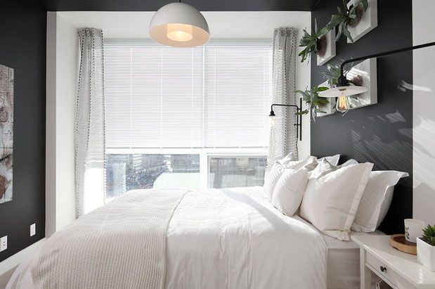 A black and white bedroom with a white bed.