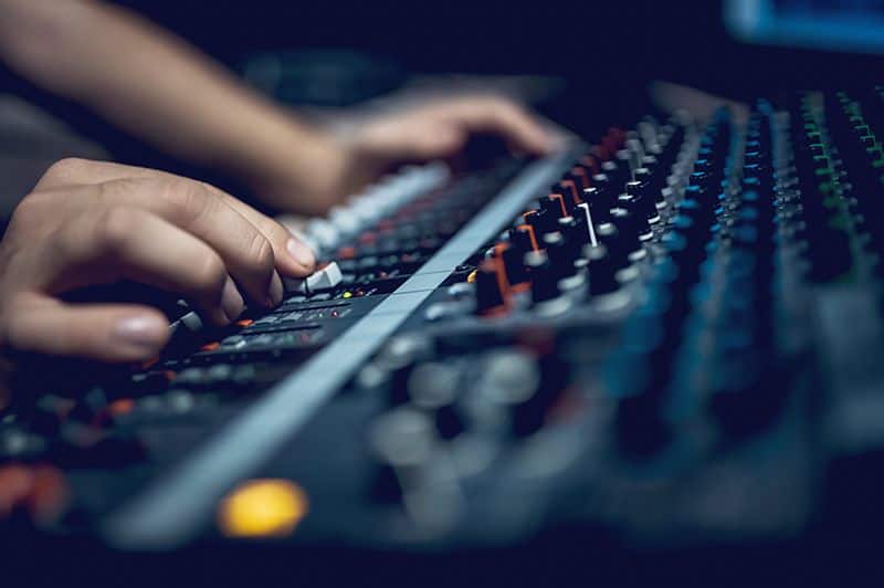 Young male dj works in modern broadcasting studio