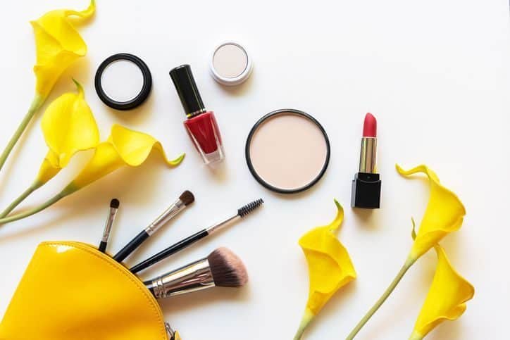 Makeup cosmetics tools and beauty cosmetics gift, products and facial cosmetics package lipstick with yellow lily flower on the white background, top view and copy space.  Lifestyle Beauty Concept