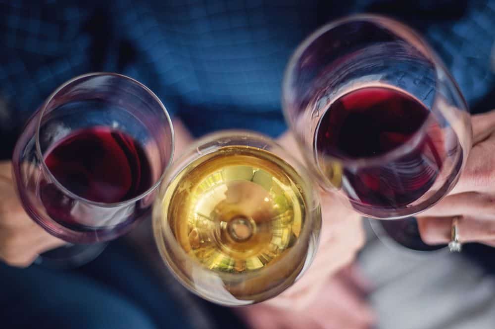 Four friends toasting with wine. Close up, shallow depth of field.