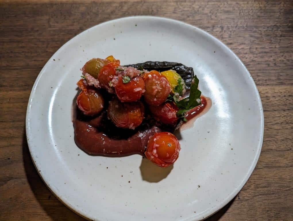 Lamb fat blistered Billy's Garden cherry tomatoes, charred eggplant from Alvarez, sour cherry sauce sourced from Little Wing. 