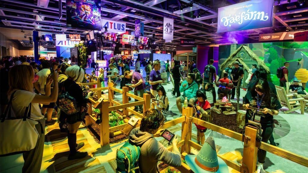 A busy gaming convention floor in Seattle with multiple booths, people trying games, and various vibrant displays featuring colorful banners and interactive setups. Among the attractions, you can find Mario-themed experiences and a life-sized Pikachu greeting enthusiastic fans.