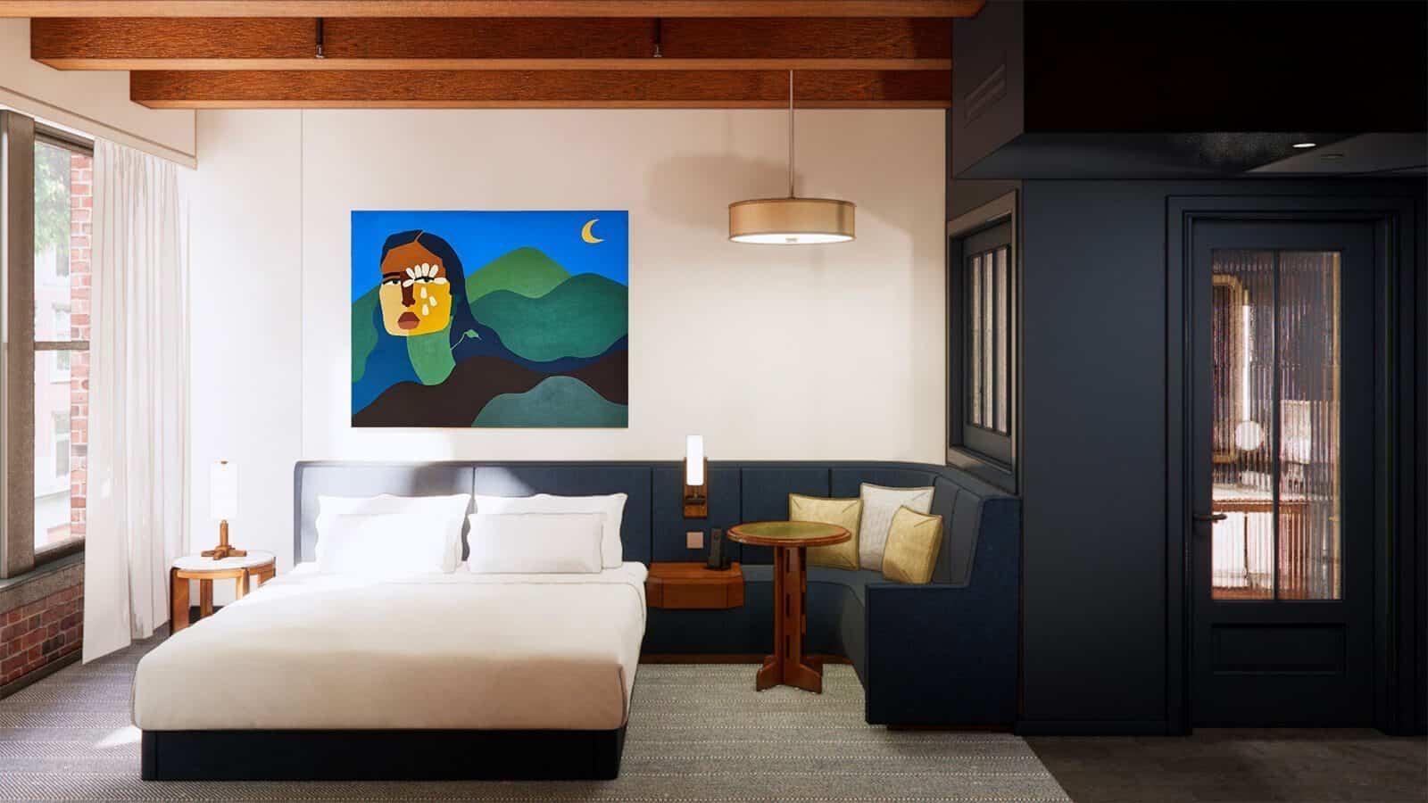 Discover an exciting hotel room adorned with a large bed, corner seating, and a round table. A colorful abstract painting graces the wall, while wooden beams and a modern light fixture enhance the ceiling's charm. Perfect for travelers eager to experience new hotels by 2025.