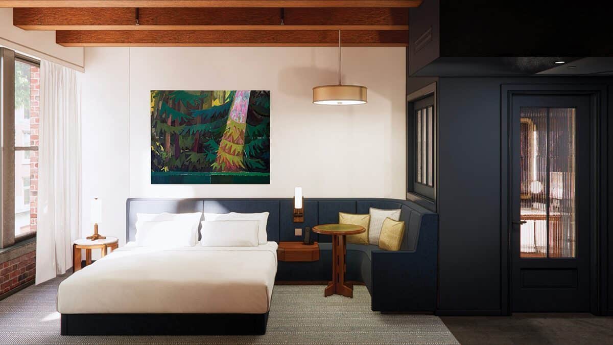 A modern hotel room in Pioneer Square Seattle with a large bed, wooden beams on the ceiling, a cozy seating area, and a colorful painting above the bed—perfect for your stay during the FIFA World Cup 2026.