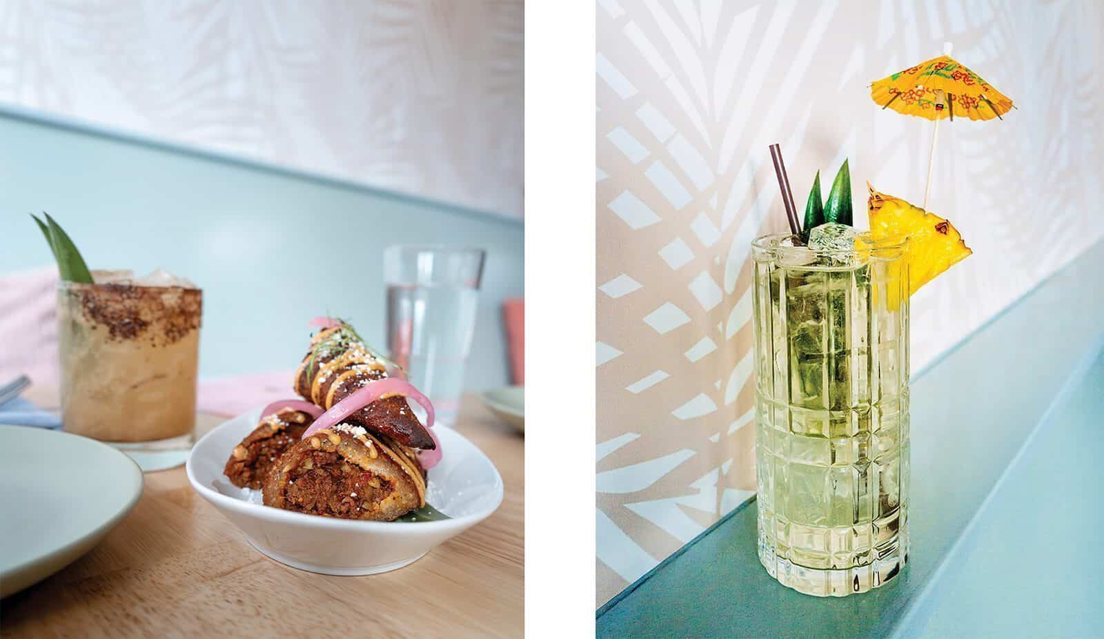 A bowl of stuffed plantains topped with onions and cheese sits next to a cocktail at Johnny Reyes; another vibrant cocktail, garnished with pineapple and a paper umbrella, completes the Lenox-inspired scene on the right.