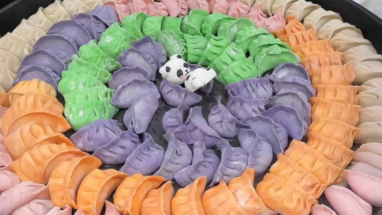 A ring of colorful dumplings in pink, orange, purple, and green surrounds a small edible panda figure in the center—perfect for celebrating Panda Fest during a vibrant Seattle summer.