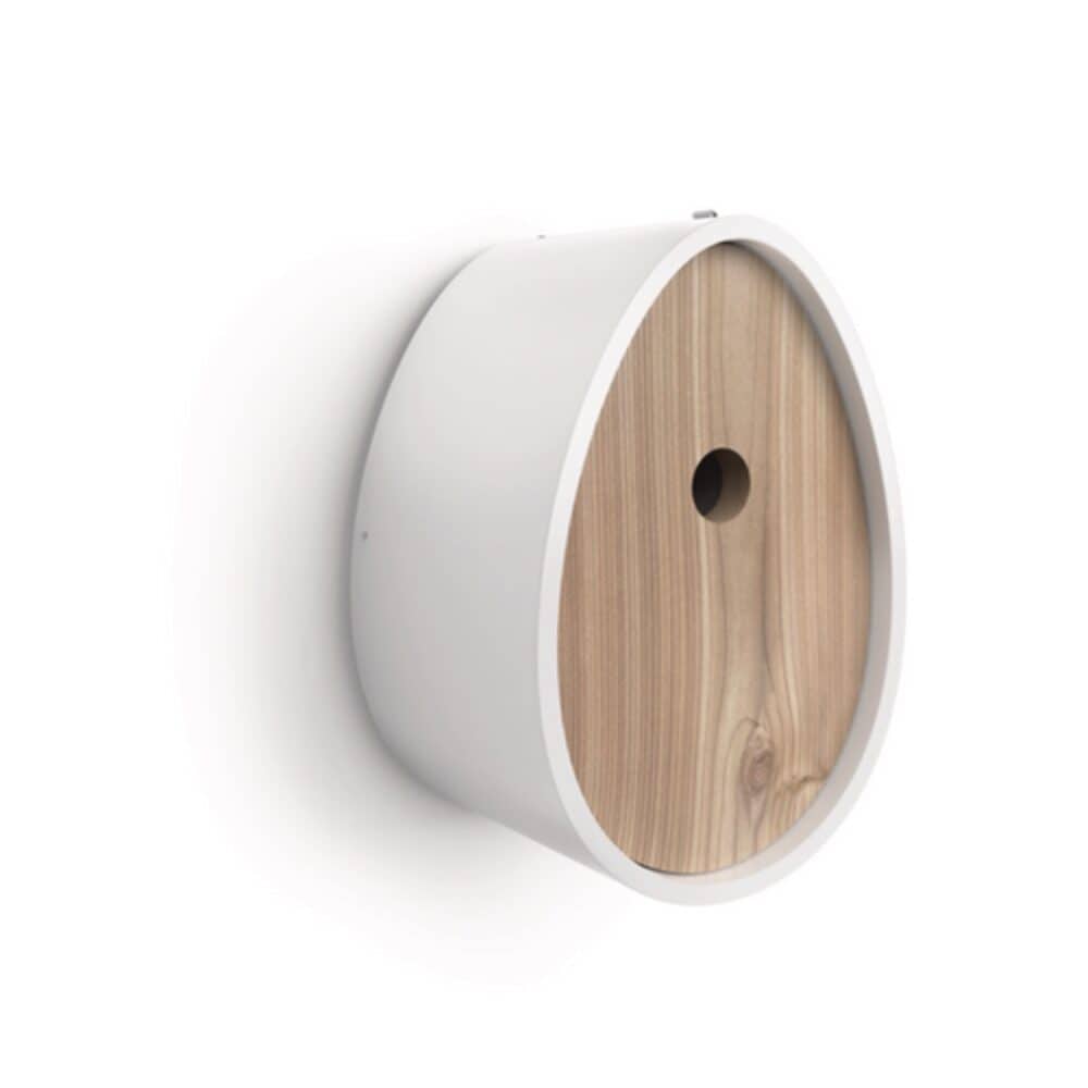 A modern birdhouse with a smooth white exterior and a wooden front panel featuring a small circular entrance hole—perfect for birds to peek out. Stylishly mounted on a white wall, it makes an ideal choice for unique holiday gifts.