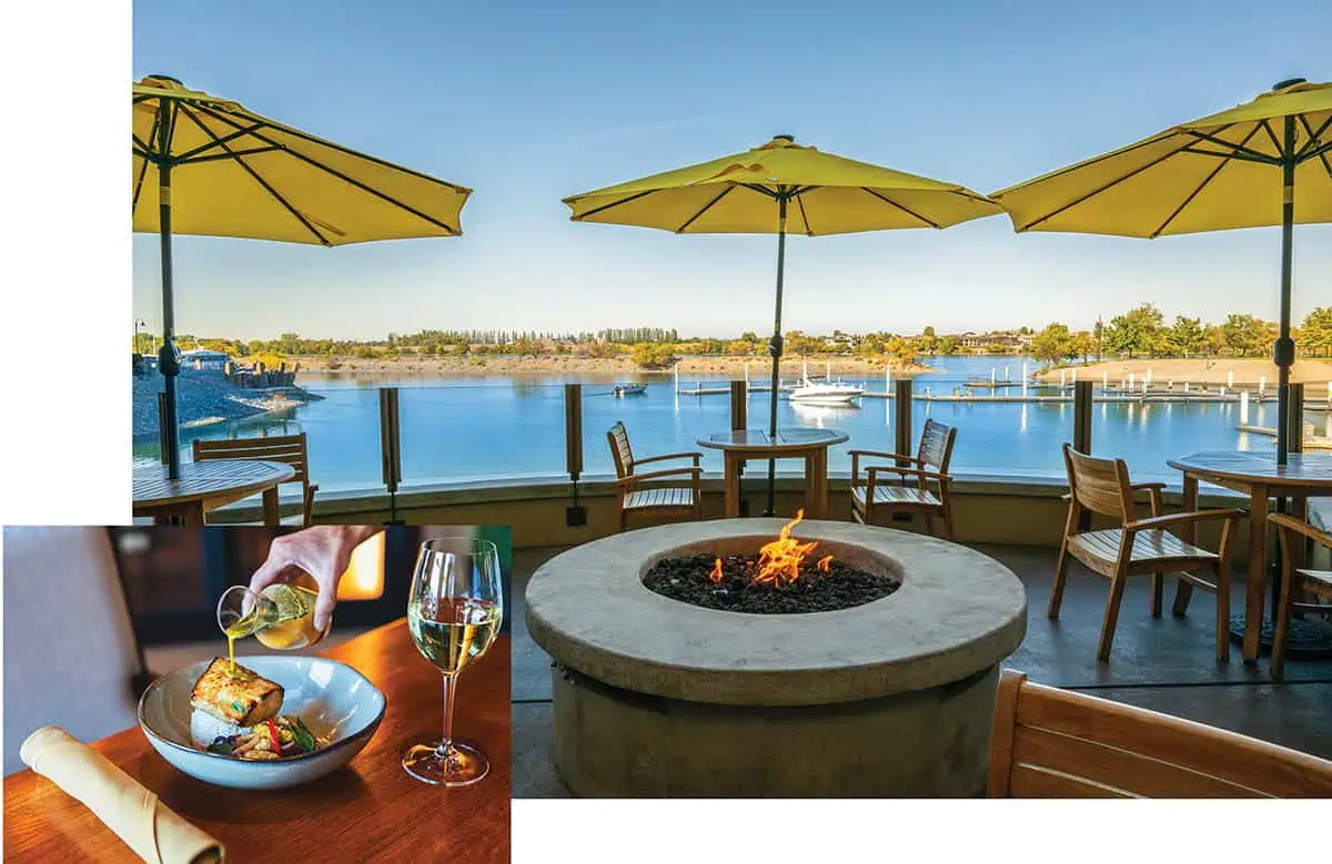 Outdoor restaurant patio with wooden tables, umbrella shades, and a fire pit overlooking a marina. Inset shows delicious food and a glass of white wine being poured, perfect for enjoying eating outdoors.