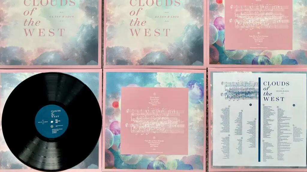 A vinyl record, cover, insert, and lyric sheet from the album "Clouds of the West" are arranged in a grid on a flat surface.