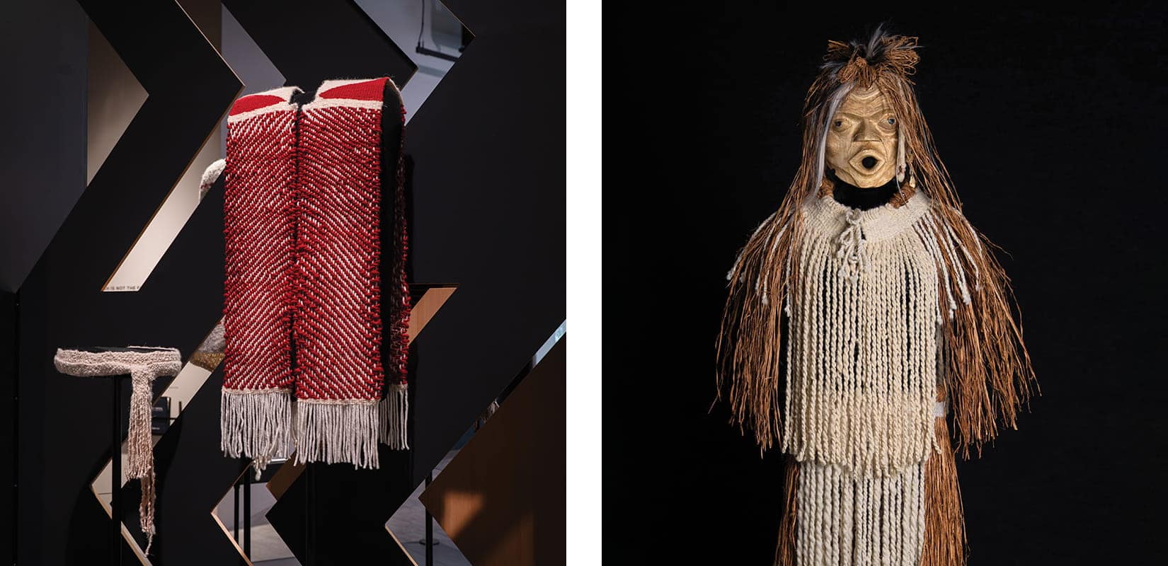 Two traditional Coast Salish garments: one red and white with fringe on display; the other beige with fringe and a mask, resembling a human figure, featured in "Woven in Wool" at the Burke Museum against a black background.