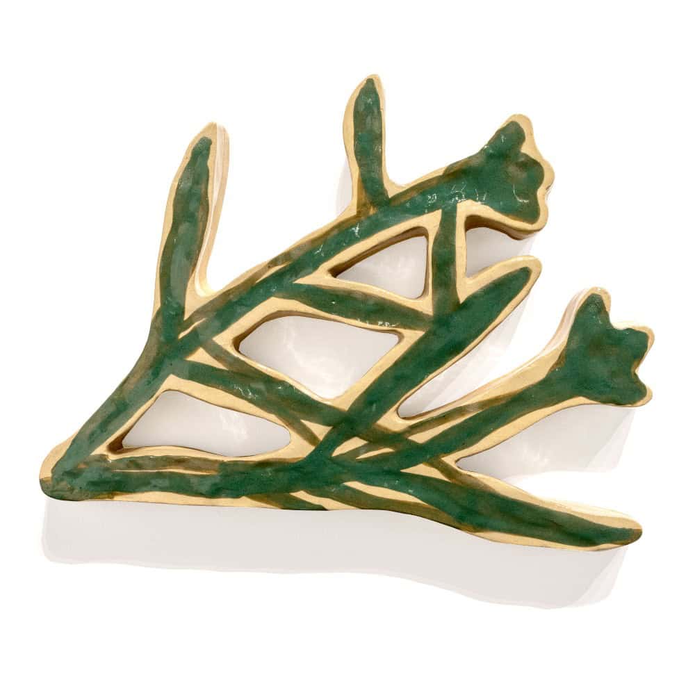 A ceramic object shaped like an abstract branch with green and gold accents, shown against a white background.