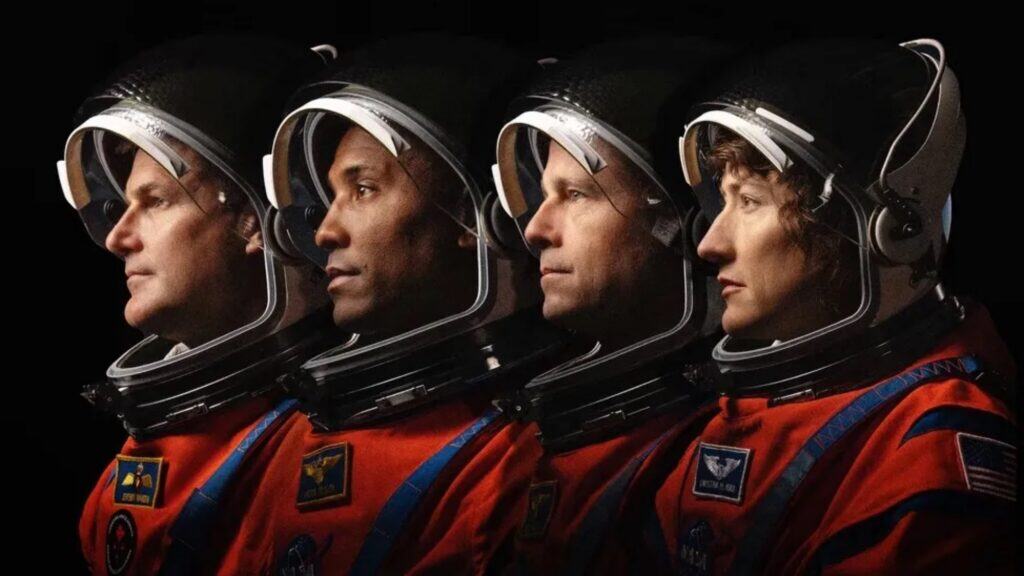 Four Artemis II astronauts in orange spacesuits and helmets are shown in profile, facing left, against a black background—capturing the spirit of exploration on their journey through Seattle.