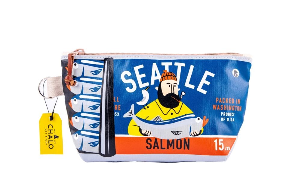 Blue and white zippered pouch with an illustration of a bearded man holding a fish, labeled “Seattle Salmon.” Tag reads “Chalo.”.