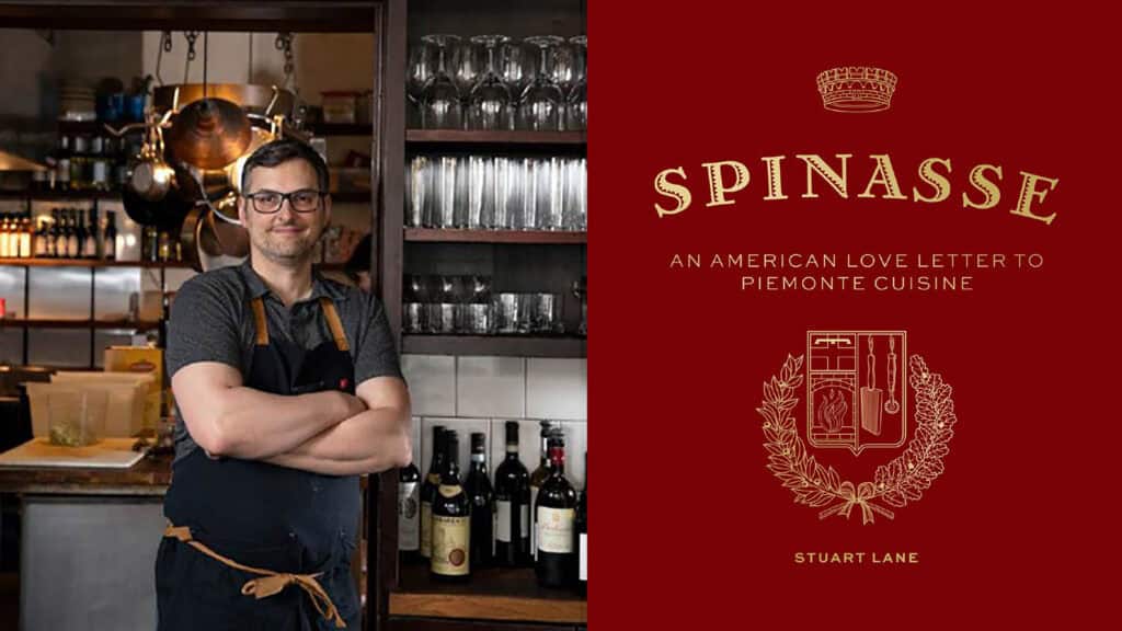 A chef stands with arms crossed in a restaurant kitchen next to wine bottles; beside him is a red book cover titled “Spinasse: An American Love Letter to Piemonte Cuisine” by Stuart Lane. Discover the inspiration behind Spinasse at Home, bringing the celebrated flavors and traditions of Piemonte right to your own kitchen.