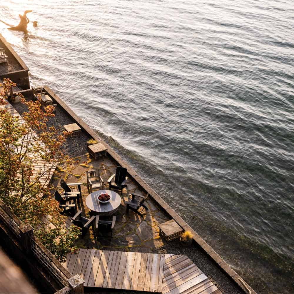 A round table and chairs on a patio overlooking the water at the Passage Restaurant.
