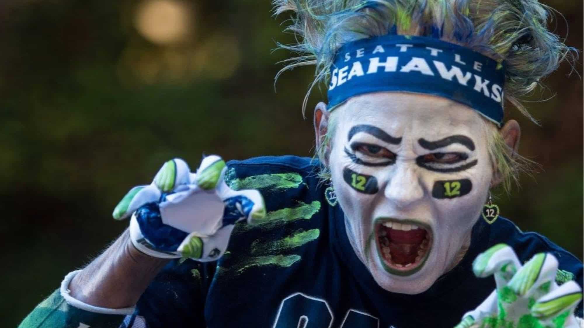 A zombie fan with face paint, a Seattle Seahawks headband, and a team jersey, posing with clawed gloves for Thrill the World.