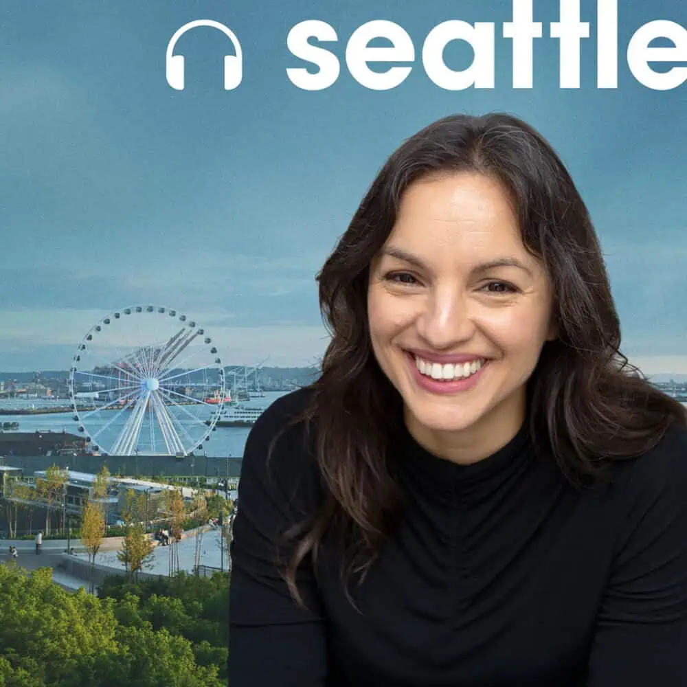 Mónica Guzmán smiles in front of a background featuring the Seattle Great Wheel and the text “seattle” with a headphone icon.