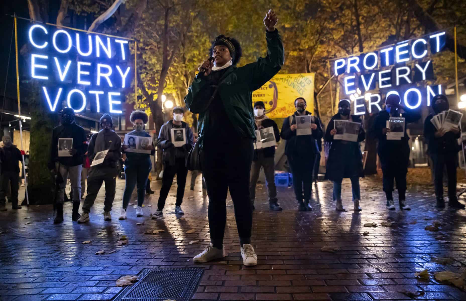 Travonna Thompson-Wiley, with Black Action Coalition, speaks at the 'Count Every Vote - Protect Every Person' rally and march in Occidental Park in Seattle Wednesday, Nov. 4, 2020. "Now is the new normal and we want Black liberation and also we want Native Sovereignty," says Thompson-Wiley. A coalition of groups organized the event, which drew hundreds of people. The coalition demanded that every vote is counted and orderly transition of power, as well as the elimination the electoral college, defunding the police, eradicating ICE/CBP and investing in Black communities. 215565