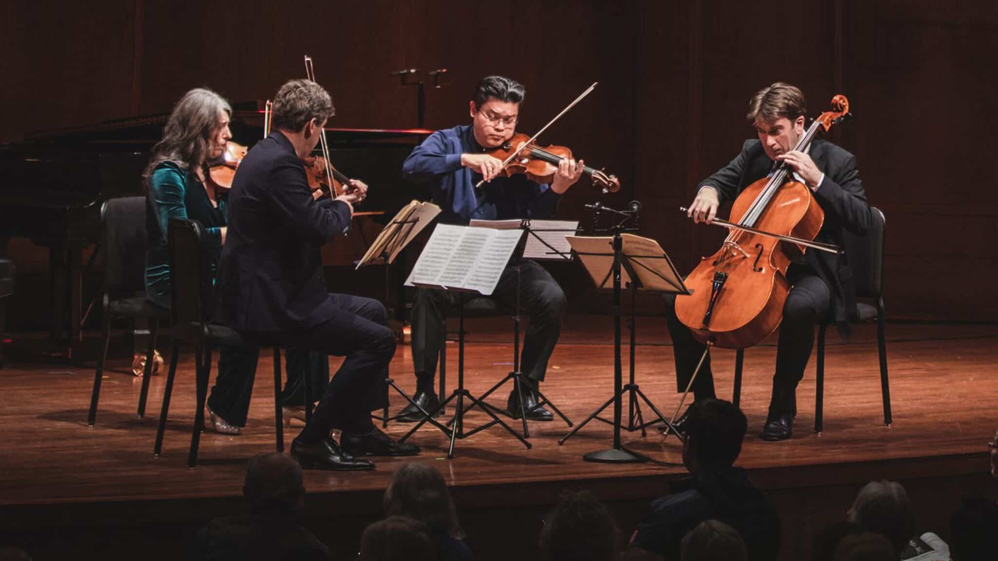 Classical musicians performing in a string quartet on stage during the Seattle art scene's spring showcase.