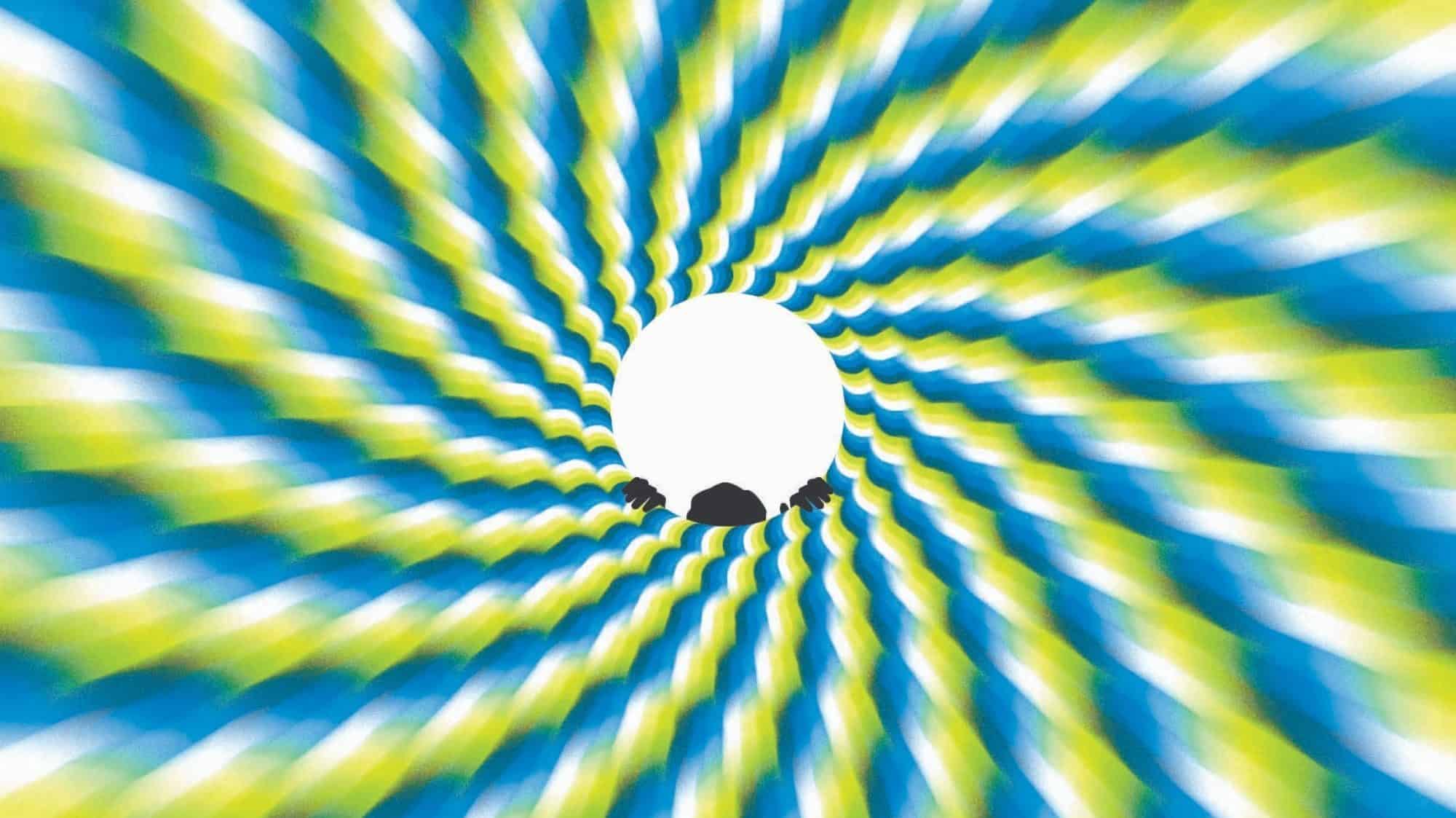A circular optical illusion with a white center, surrounded by spiraling blue, green, and yellow patterns, creating a psychedelic sense of motion. Black silhouettes are present at the bottom of the image.