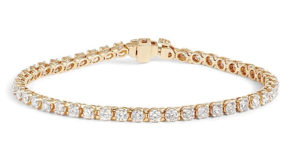 A gold tennis bracelet featuring a single row of round, clear gemstones set in individual prongs with a clasp closure—an elegant choice for meaningful gifts.