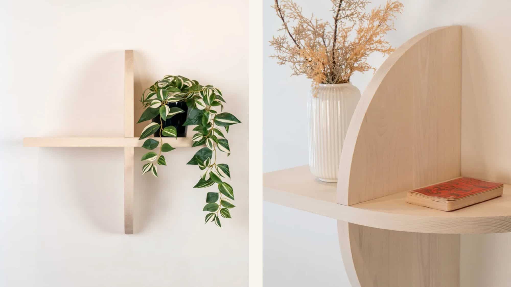 Left: A light wood cross-shaped wall shelf with a trailing potted plant. Right: A curved wood shelf with a vase of dried foliage and a closed book.