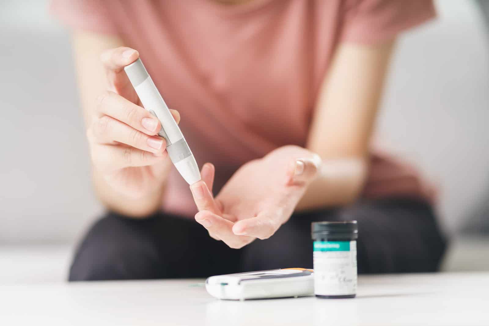 asian-woman-using-lancet-on-finger-for-checking-blood-sugar-level-by-glucose-meter-healthcare-and-medical-diabetes-glycemia-concept