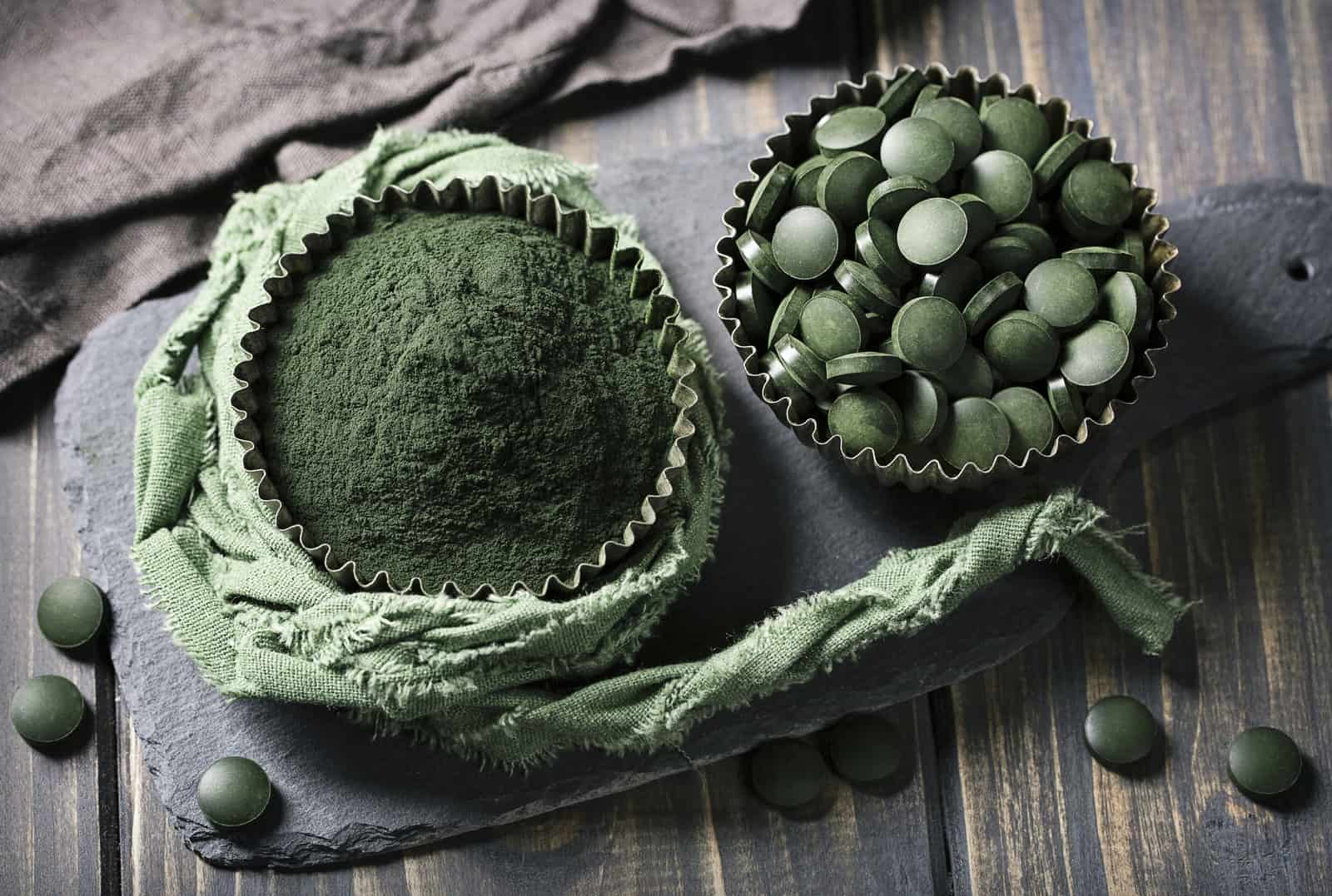 spirulina-tablets-and-powder-in-bowls-on-a-wooden-background