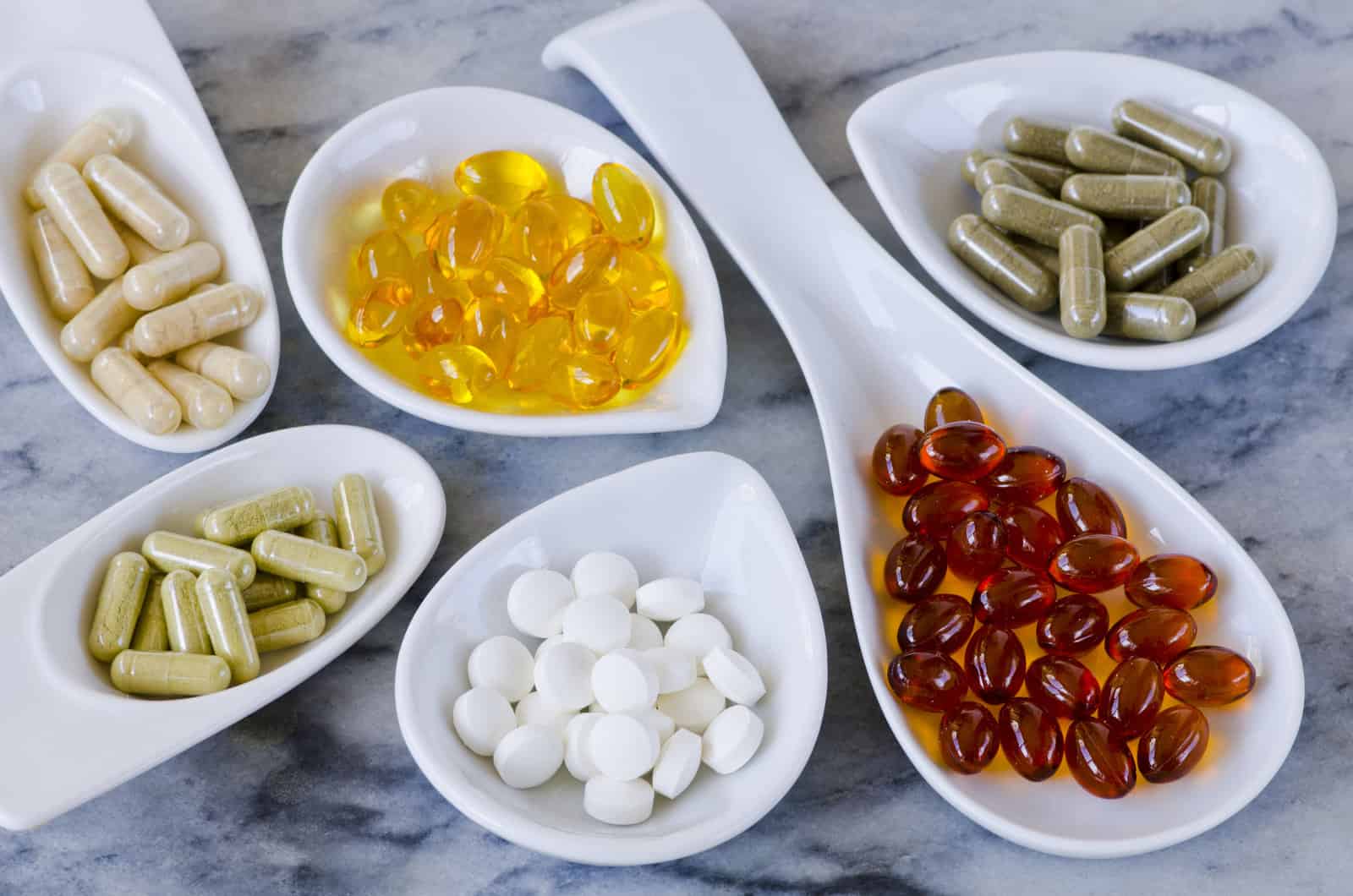 variety-of-dietary-supplements-including-capsules-of-garlic-evening-primrose-oil-artichoke-leaf-olive-leaf-magnesium-and-omega-3-fish-oil-selective-focus-taken-in-daylight