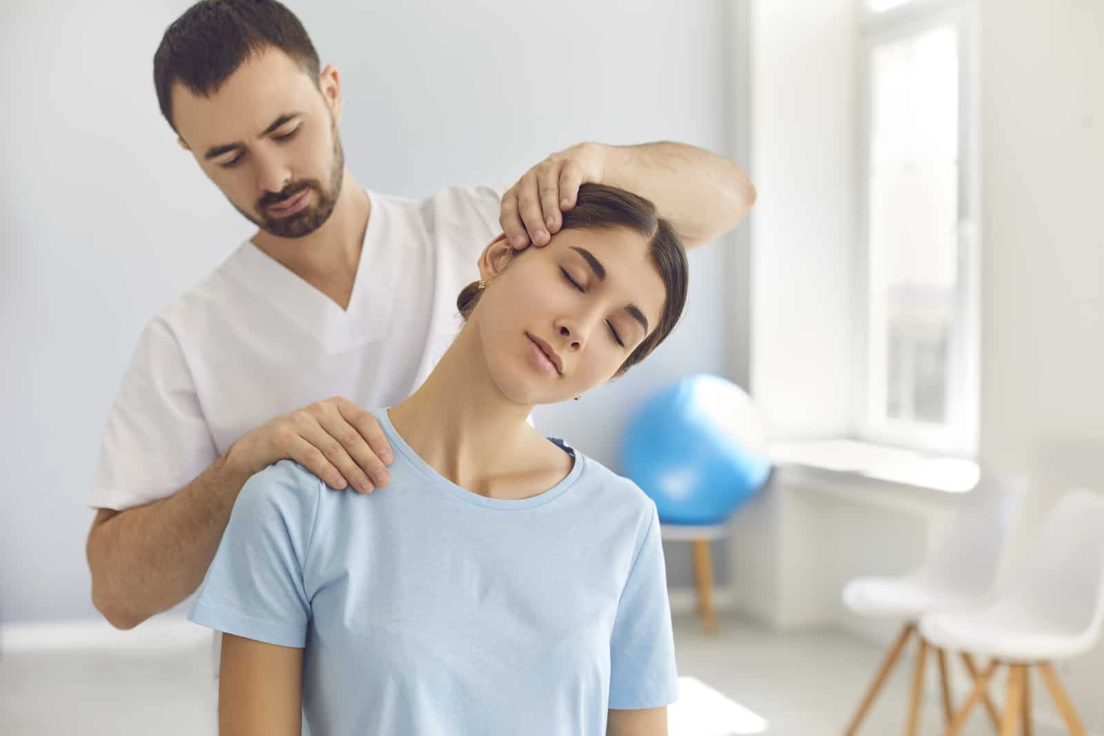 licensed-chiropractor-or-manual-therapist-doing-neck-stretch-massage-to-relaxed-female-patient-in-clinic-office-young-woman-with-whiplash-or-rheumatological-problem-getting-professional-doctors-help