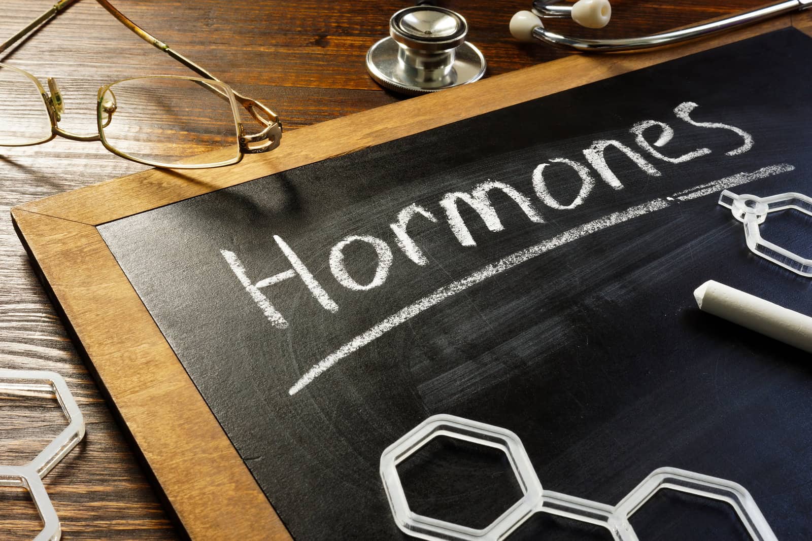 handwritten-word-hormones-on-the-blackboard-and-glasses